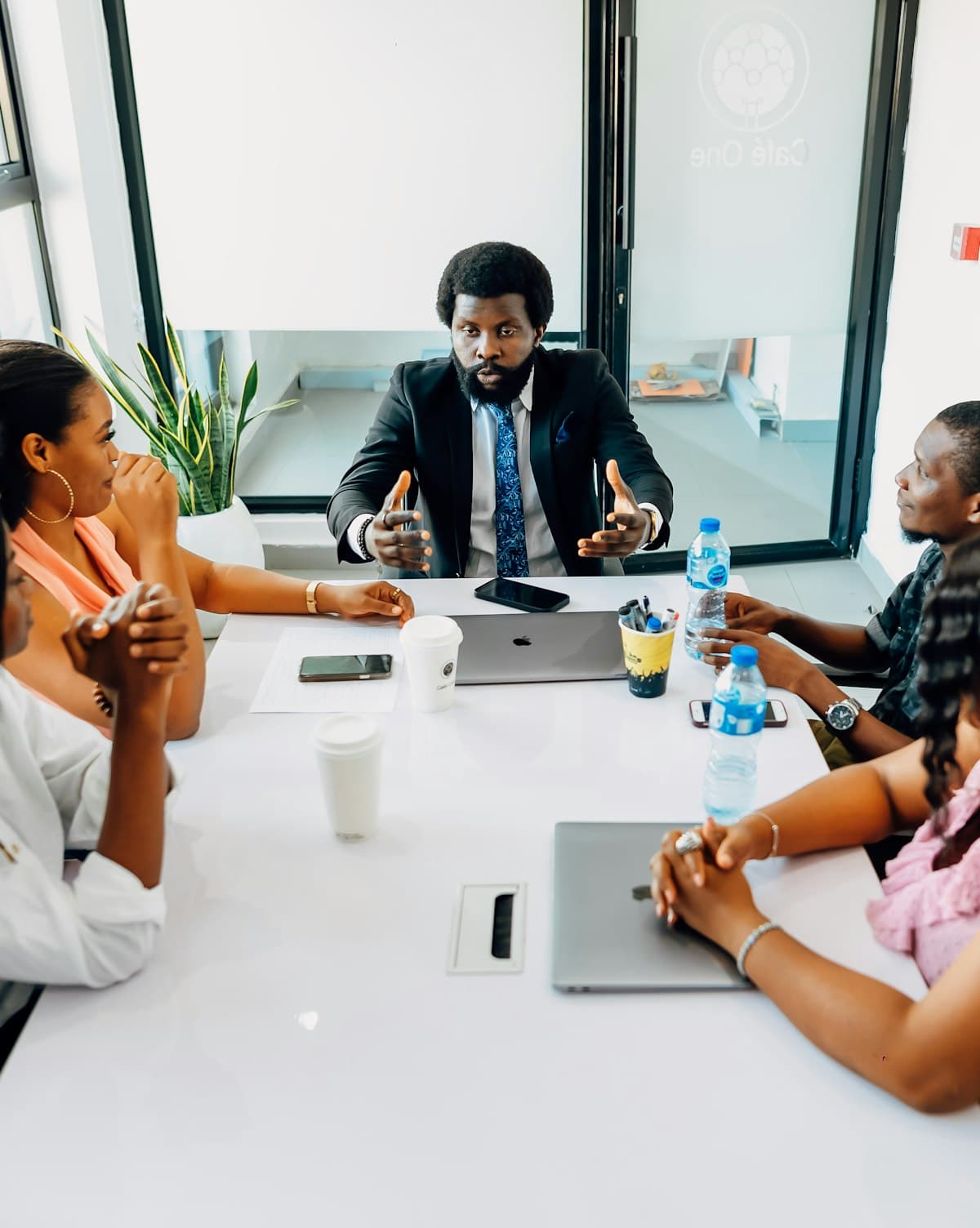 A team meeting around a table with laptops in a Lagos office